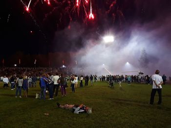 Firework display over people at night