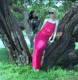 Portrait of smiling mature woman standing against boy on tree