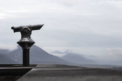 Close-up of coin-operated binoculars against sky