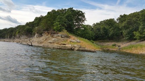 Scenic view of river against cloudy sky