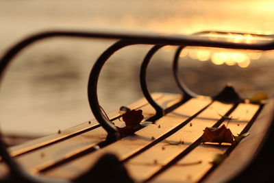 Close-up of metal grate against sky during sunset