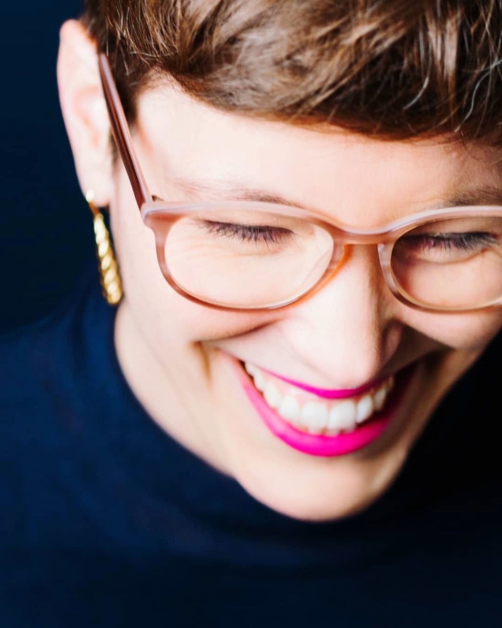 close-up, one person, portrait, headshot, emotion, smiling, happiness, glasses, young adult, eyeglasses, body part, human body part, human face, studio shot, indoors, adult, toothy smile, teeth, brown hair, black background, teenager, beautiful woman, hairstyle, bangs