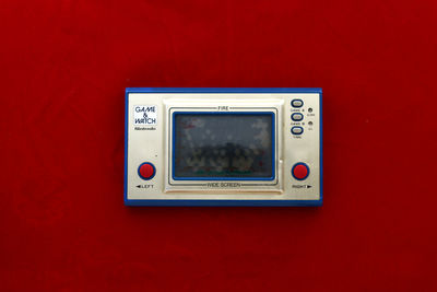 Photo of a vintage game console on a red table.