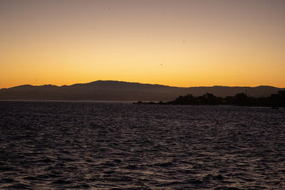 Scenic view of sea against orange sky