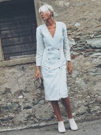 Full length of young woman standing by railing