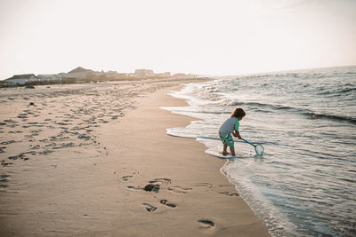 Boy on beach at sunrise