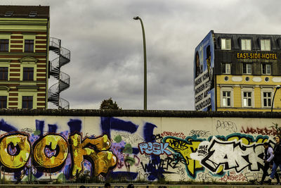 Graffiti on building against sky in city