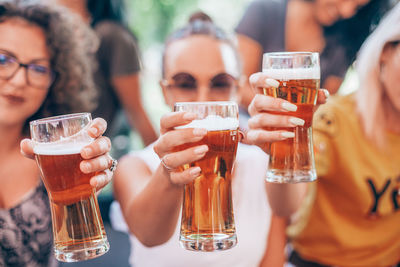 Portrait of smiling women showing beer glasses at party