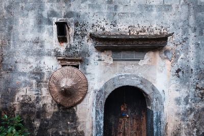 Asian style conical hat hanging on abandoned house