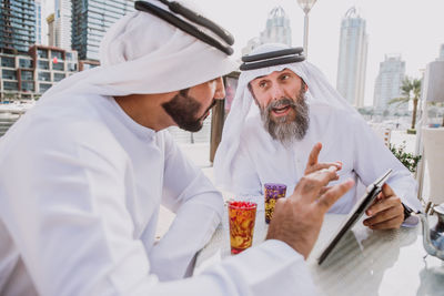 Portrait of man holding mobile phone in city