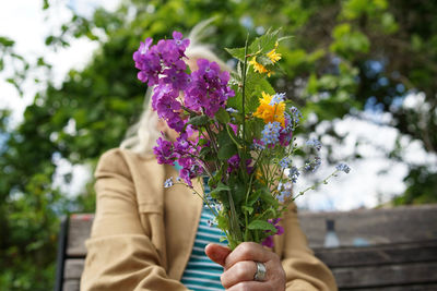 Woman holding flowers at yard