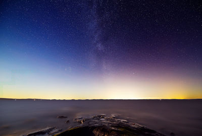 Scenic view of snowcapped mountains against sky at night