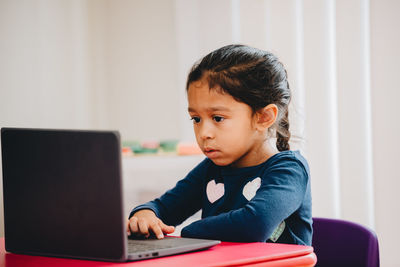 Boy sitting on table at home