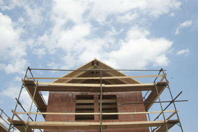 Carcass of a single family house with roof and scaffolding