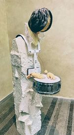 Woman standing on table against wall