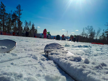 Surface level of snow covered field against sky