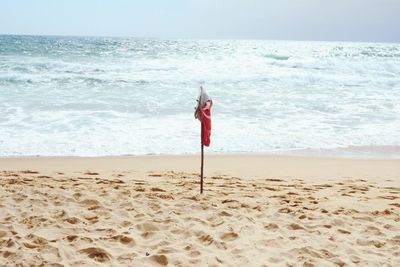 Woman standing on beach against sky