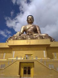 Low angle view of statue against building against sky