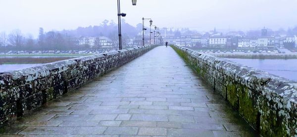 Footpath by street against sky