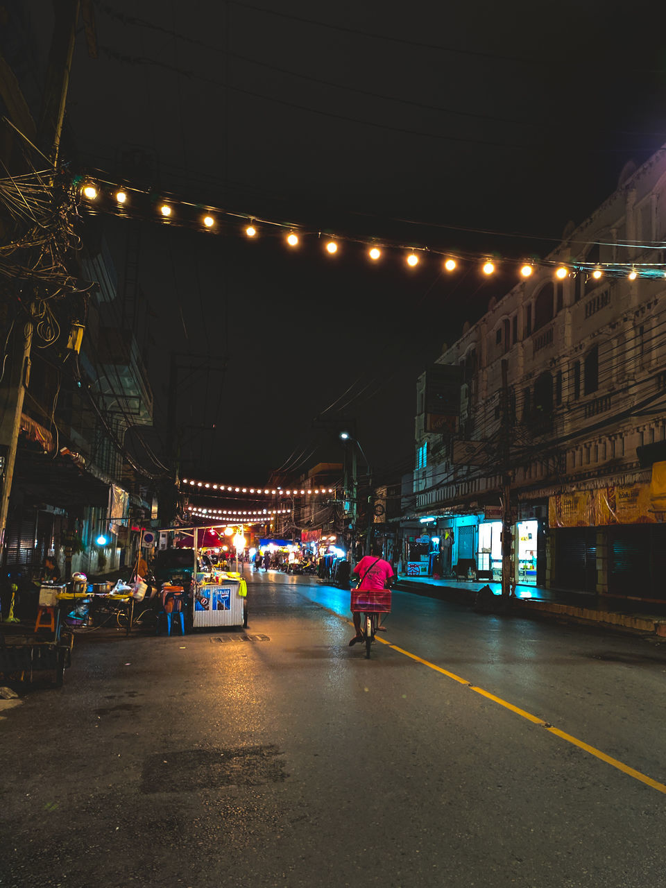 illuminated, night, architecture, built structure, transportation, real people, lighting equipment, city, street, building exterior, lifestyles, road, group of people, men, group, women, mode of transportation, people, motion, the way forward, outdoors, light