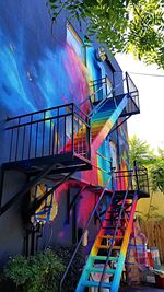 Low angle view of staircase by building against blue sky