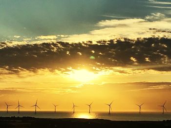 Silhouette of wind turbines at sunset