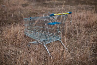 Empty shopping cart on field