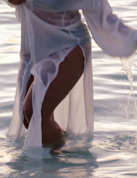 Low section of woman standing on beach