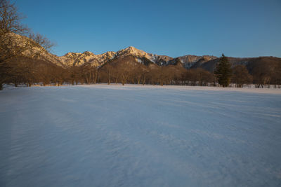 Scenic view of snowcapped mountains against clear blue sky