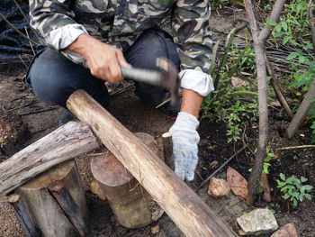 Full length of man holding log in forest