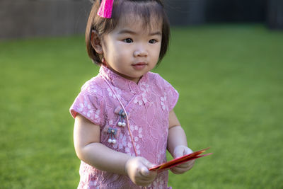 Portrait of cute girl lying on field