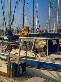 Sailboats moored at harbor against clear blue sky