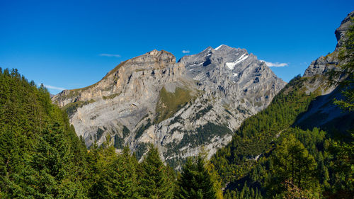 Low angle view of mountains against clear blue sky