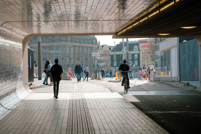 People walking on footpath in city