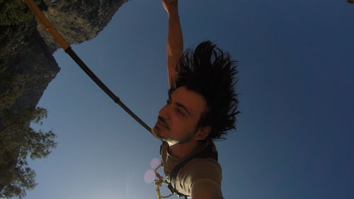 Low angle view of woman looking away against sky