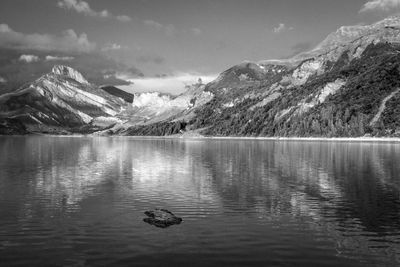 Scenic view of lake and snowcapped mountains against sky