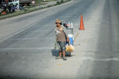 Side view of woman walking on road in city