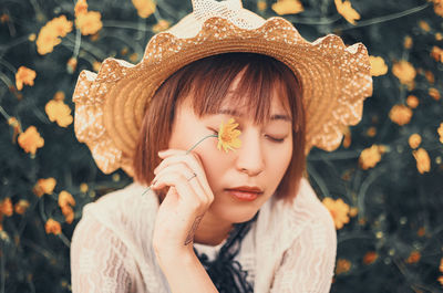 Close-up portrait of young woman wearing hat