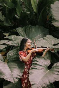 Young woman holding plant