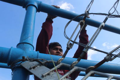 Low angle view of boy on slide at playground