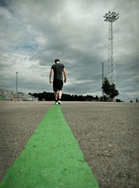 Rear view of man walking on road