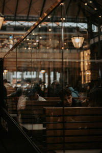 Rear view of woman standing in illuminated building