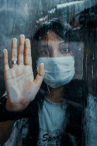 Close-up portrait of wet glass window