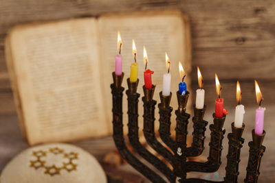 High angle close-up of lit colorful candles on wooden table