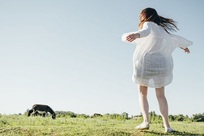 Woman standing on field against sky