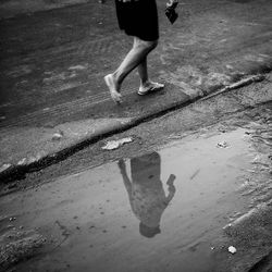 Low section of woman walking on puddle