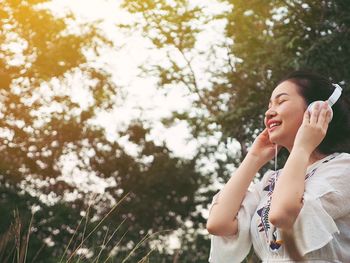 Low angle view of young woman wearing headphones