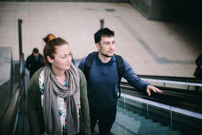 Young man and woman standing on staircase