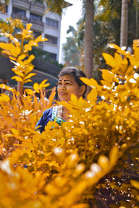 Portrait of woman with yellow flowers on tree