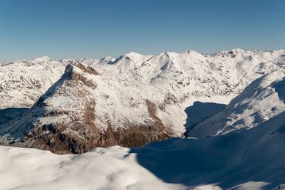 Close-up of snow covered mountain against clear sky